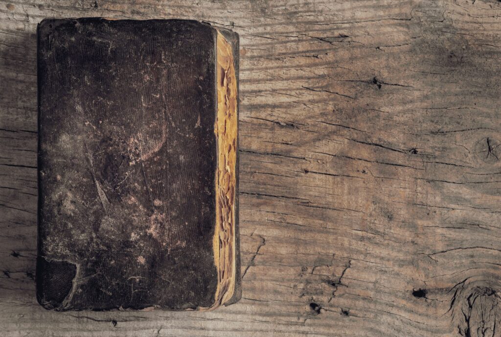 Top view of an ancient book with weathered leather book cover on a table with copy space